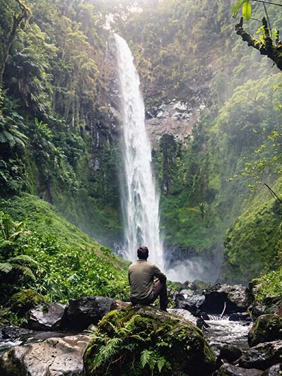 Person doing mindful movement outdoors near a waterfall on Kilimanjaro