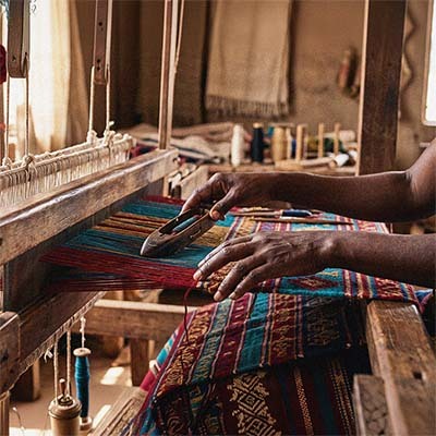 Close-up of hands weaving traditional craftwork as part of a community initiative